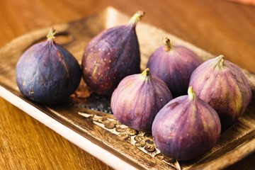 Beautiful ripe figs in rustic decorated wooden bowl