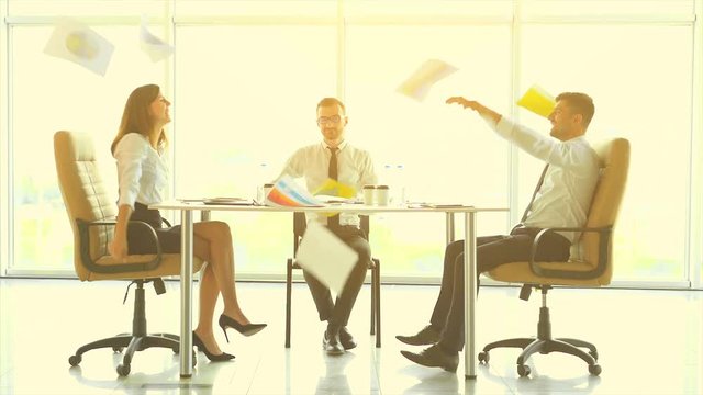 The business people at the table throw papers. slow motion