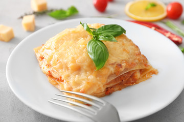 Plate with tasty lasagna on table