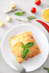 Plate with tasty lasagna on table