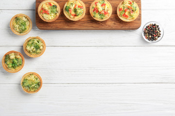 Composition with broccoli quiche tartlets on table