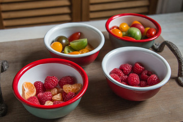 Snack idea, crackers, cheese, tomatoes, mandarin in enameled bowls 