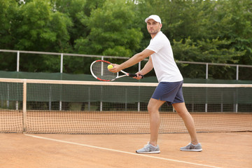 Young man playing tennis on court