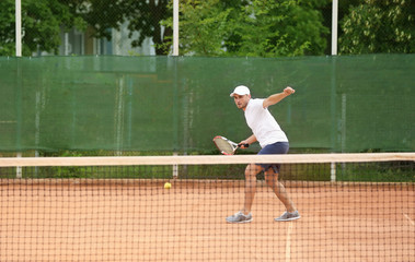 Young man playing tennis on court