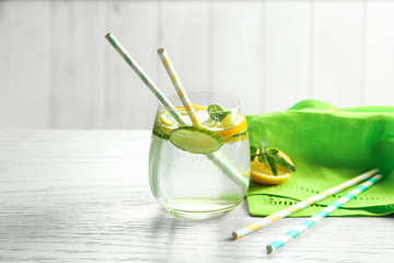 Delicious refreshing water with cucumber in glass on table