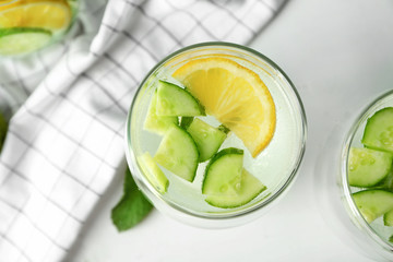 Delicious refreshing water with cucumber in glass on table