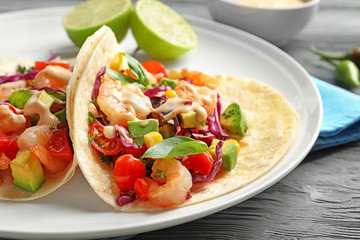 Plate with delicious shrimp tacos on wooden table