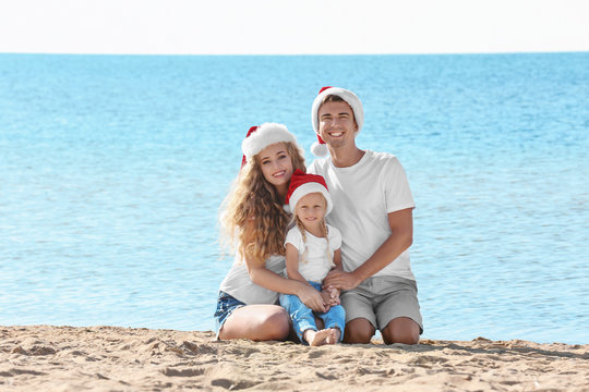 Young couple with girl on beach. Christmas celebration concept
