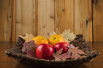Autumn Apples and Oranges in a basket with fall leaves