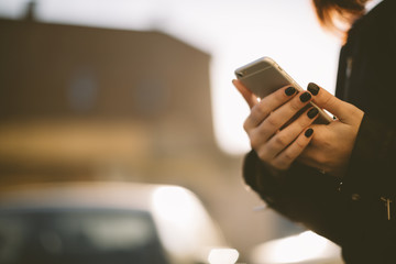 young woman using phone on the street