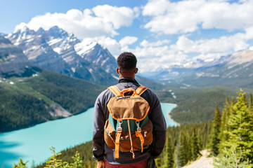 A man hiking with a backpack & looking down at moutains
