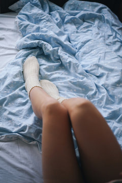 Woman In Cosy Winter Socks Lying In The Bed