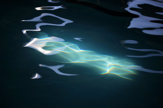 An Abstract Patch Of Sunlight Hitting A Pool Of Dark Water