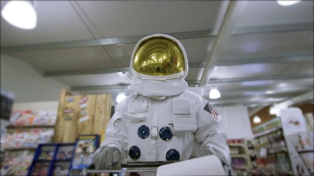  Off duty astronaut walking through supermarket, shopping for groceries