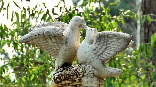 Statue of two pigeons Two kisses of birds of pigeons, stone sculptures of two birds of autumn park