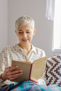 Senior Woman Reading a Book at Home
