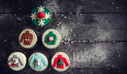 Obraz na płótnie Canvas Christmas decorative cupcakes on wooden background with blank space