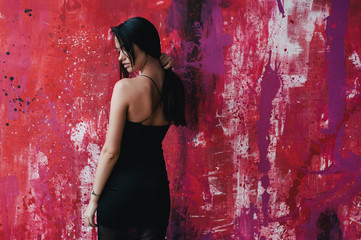 Young brunette standing in front of painted wall