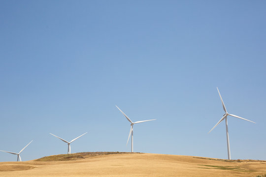 Wind turbines set against a sunny blue sky