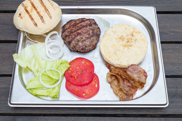 set of products for making burger on a metal tray