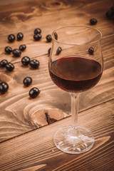 Glass of red wine and grapes on rustic wood table