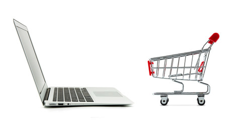 Shopping cart and laptop computer isolated on white background, shop online concept.