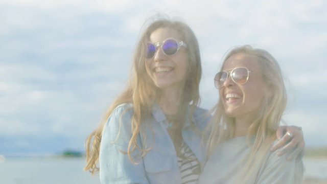 Two Beautiful Happy Girls Laugh and Celebrate Holi Festival while Colorful Powder Flying Behind They're Backs. They Have Time of Their Lives. Shot on RED EPIC-W 8K Helium Cinema Camera.