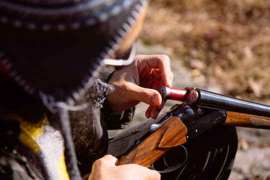 A model inserting a cartridge into a shotgun