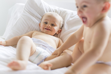 Obraz na płótnie Canvas Twin baby boy child play fun in bed