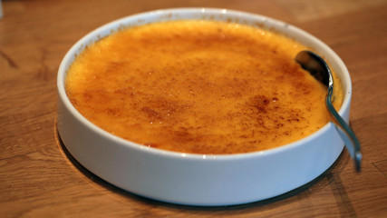 dessert detail - creme brulee in a white bowl with spoon