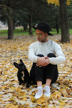portrait of a young male owner and his little french bulldog