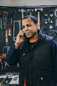 Mechanical Operator Talking by Phone in a Motorbike Workshop