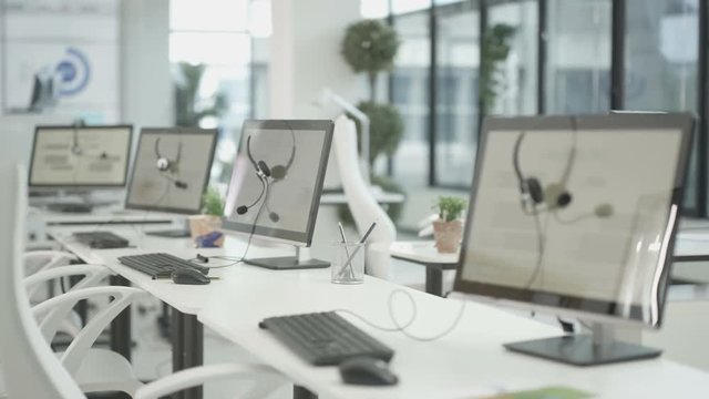  Workstations in a telesales office, headsets on computer monitors