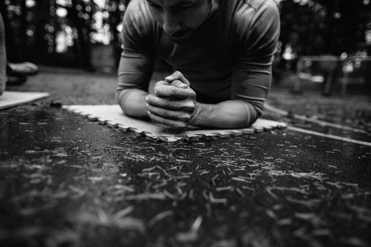 Man holding plank outside on wet ground