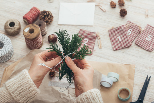 DIY Christmas - Female Hands Tying Fir Twigs Together for Homemade Xmas Gift