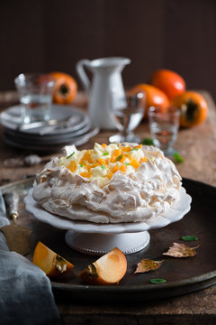 Pavlova with custard and persimmon on a cake stand