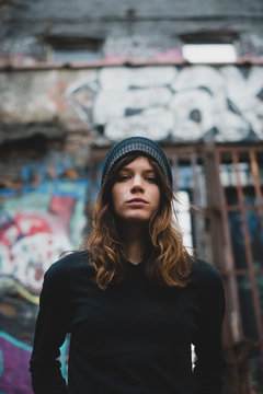 Young woman standing against graffiti