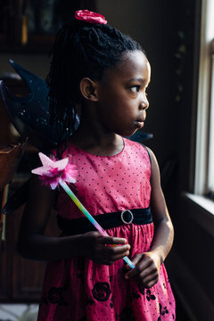 Black girl in pink fairy dress holding a wand