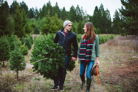 Attractive young couple at christmas tree farm in the winter.