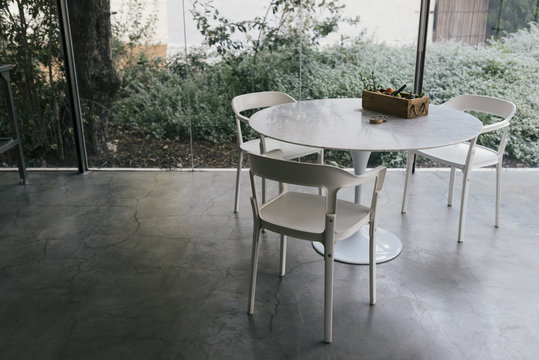 Modern Farmhouse Glass Kitchen with three plastic chairs and table on glass veranda