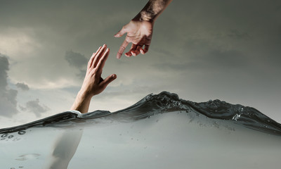 Hand of person drowning in water