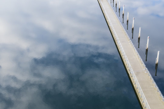 Walkway over lake with sky reflection