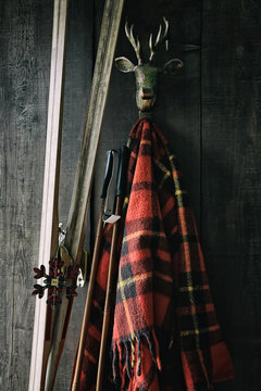 Skis and poles leaning against plaid blanket