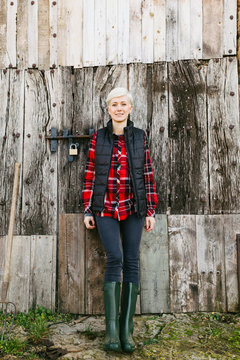 Blonde woman standing in front of a wooden door.