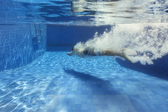 Man underwater after a headplunge in the pool