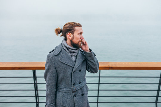 Young stylish businessman in the city by the river