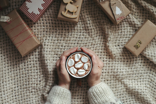Drinking cocoa surrounded by Christmas gifts