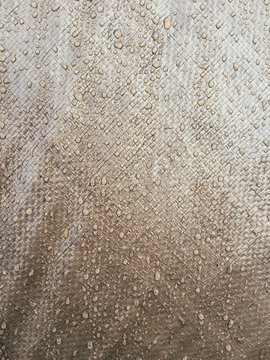 Raindrops on brown tarpaulin