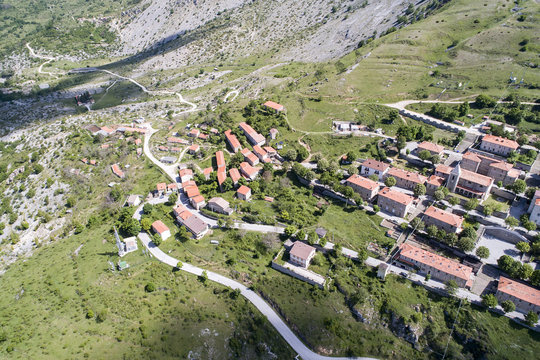 Vista aerea di una strada di montagna con un piccolo paese