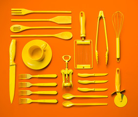 Well organised yellow kitchen objects on orange background.